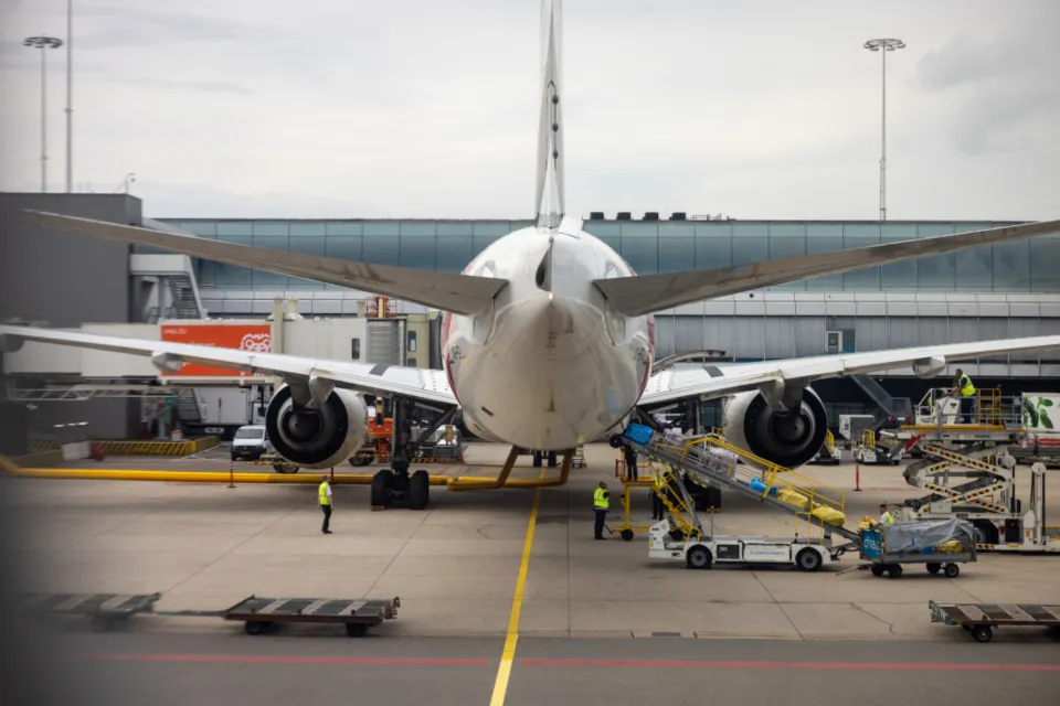 Pesawat jet terparkir di gerbang bandara sementara petugas darat memuat bagasi