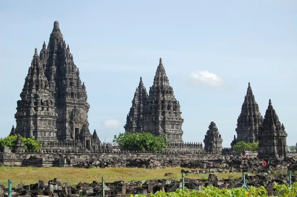 Kompleks candi Prambanan dengan menara-menara batu runcing di bawah langit biru